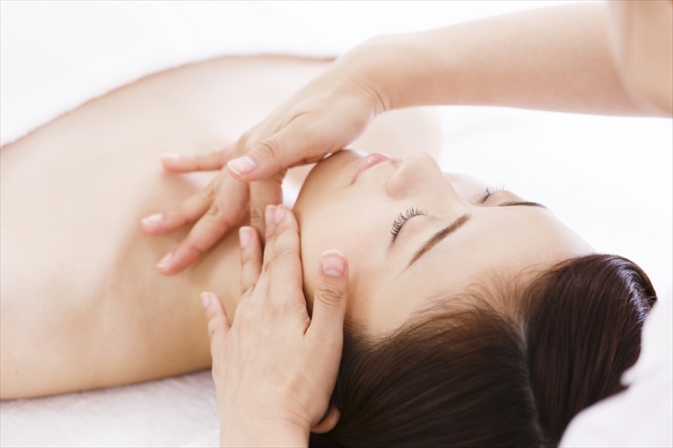 小顔エステ施術中、リラックスした表情の女性